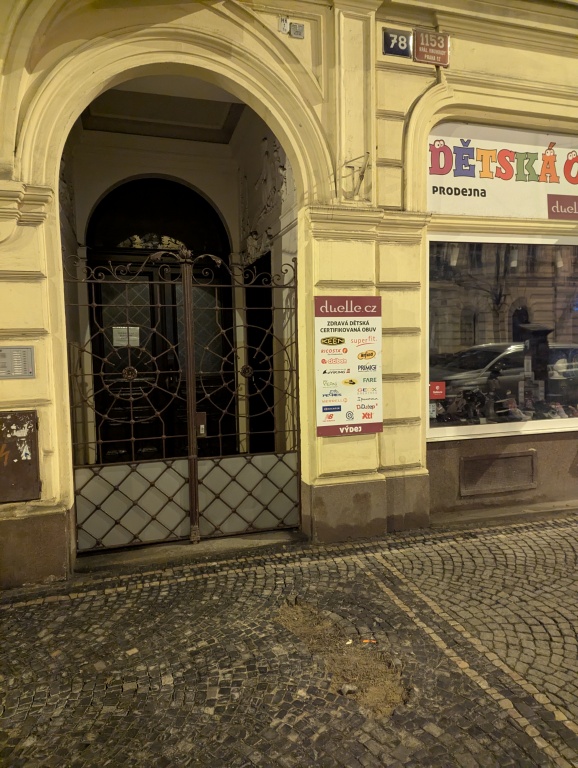 Poškozená dlažba na chodníku před domem Korunní 78