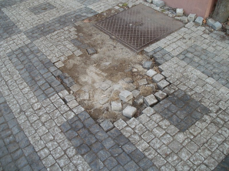 Rozbitý chodník v ulici Ostrovského, Praha 5