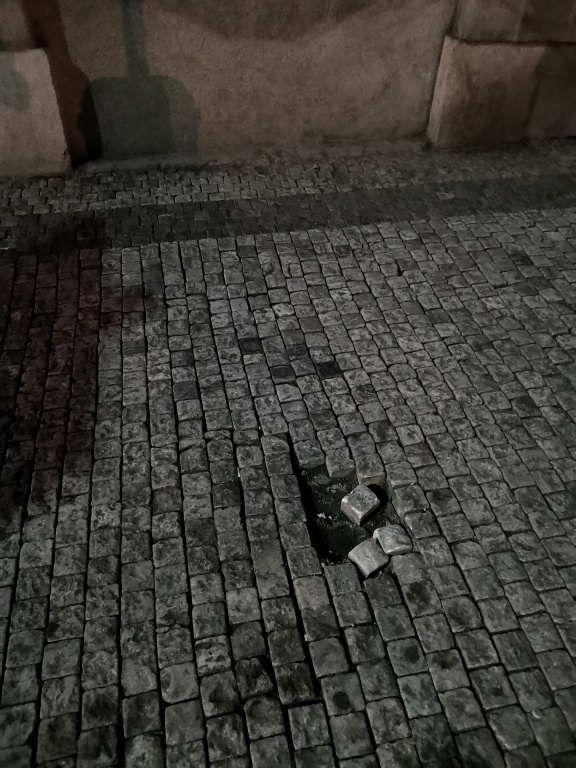 Vypadaná dlažba na rohu ulic Na Moráni a Karlovo nám.