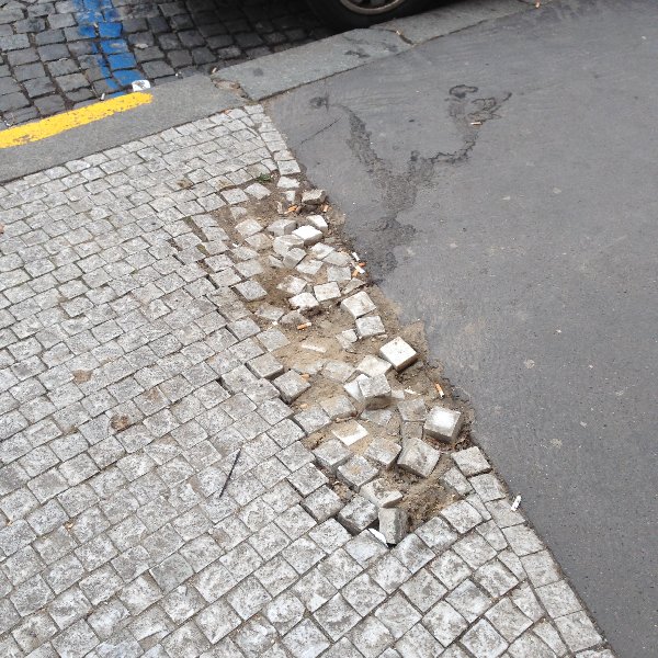 Rozpadající se chodník na rohu Slezské a Kolínské