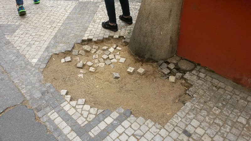 Rozbitý chodník v ulici Karlova