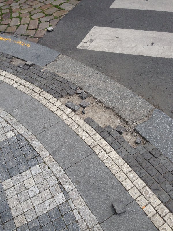 Rozbitá dlažba na nároží Radhošťské a Vinohradské