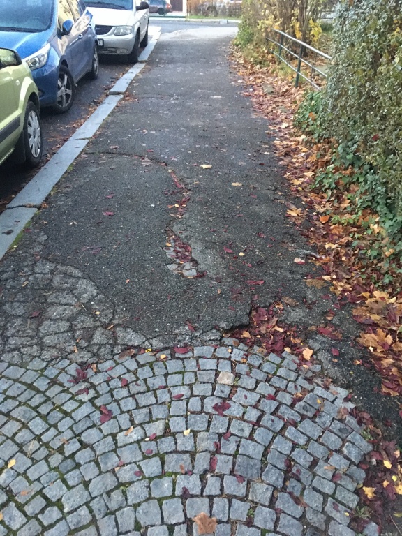 Výtluk v chodníku přímo před vchodem do ZŠ Na Dlouhém lánu