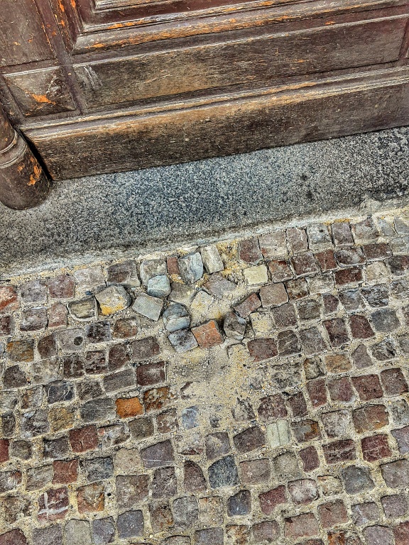 Rozbitá dlažba chodníku před vchodem do domu Valentinská 1/91, Praha 1
