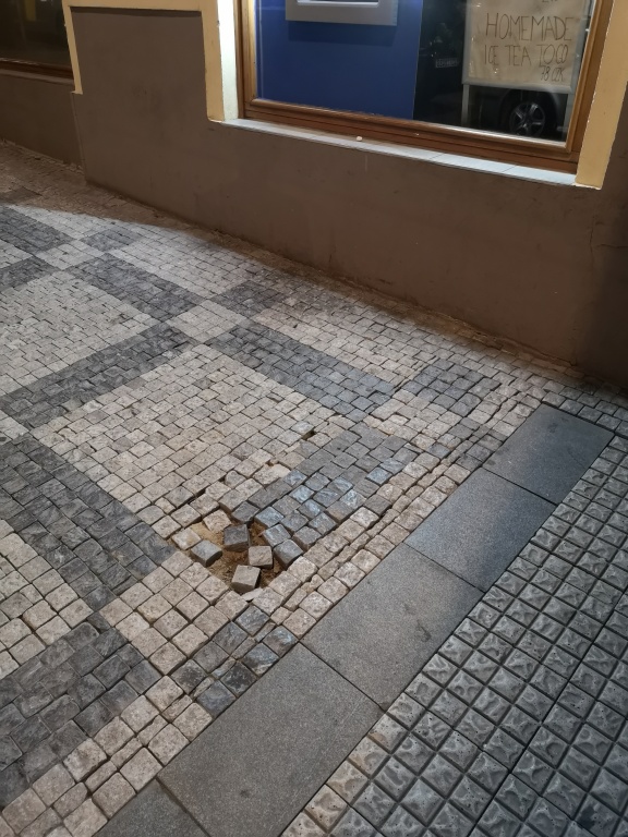 Drolící se dlažba na chodníku v ul. Vinohradská
