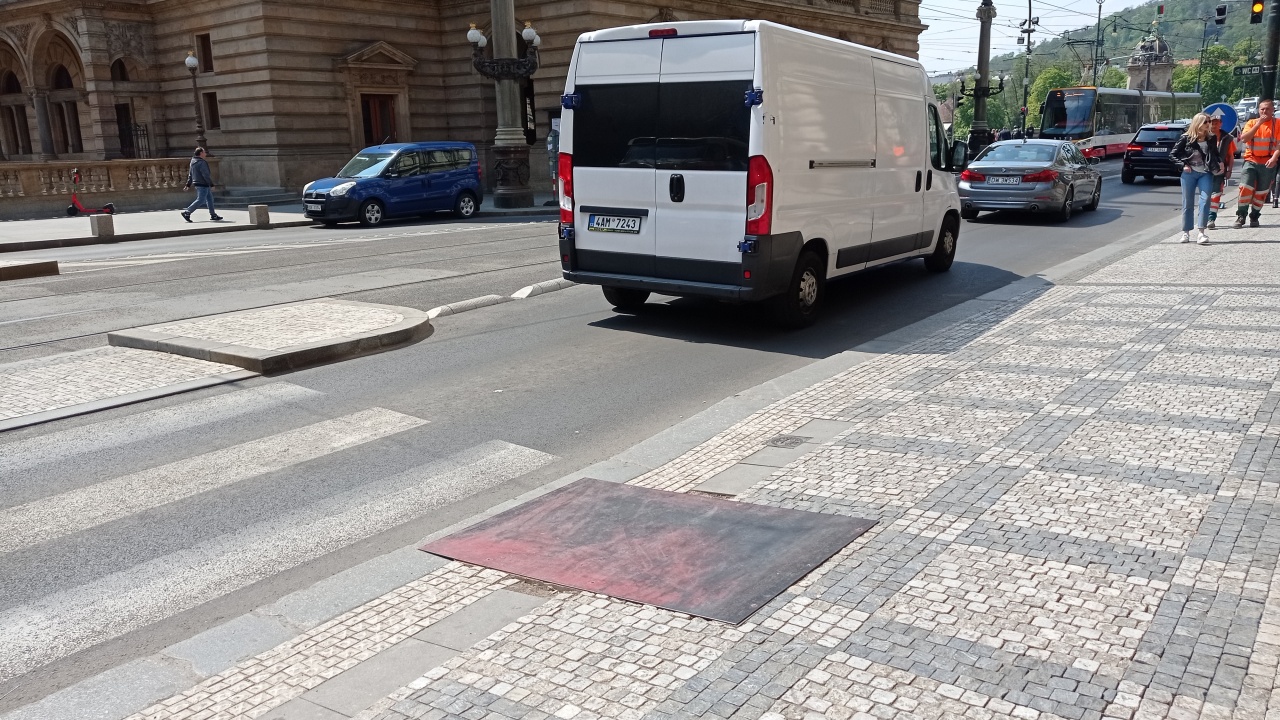 Plech na chodníku před přechodem v ulici Národní