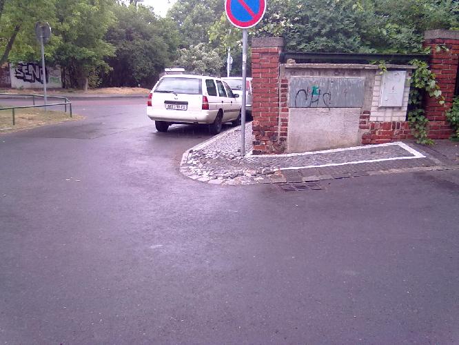 Rozrytá dlažba na rohu chodníku