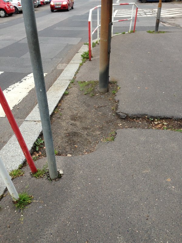 Chybějící kus chodníku na rohu Kafkovy ulice