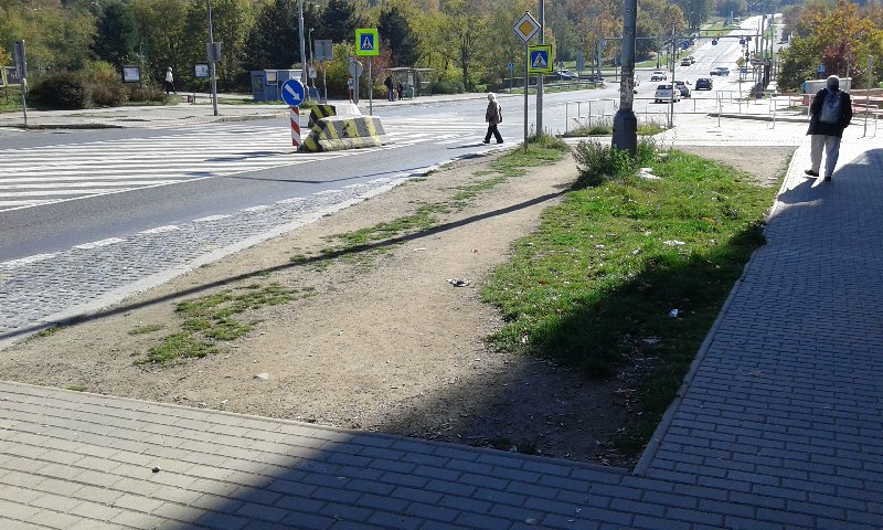 Neudržovaný trávník u zastávky Poliklinika Modřany