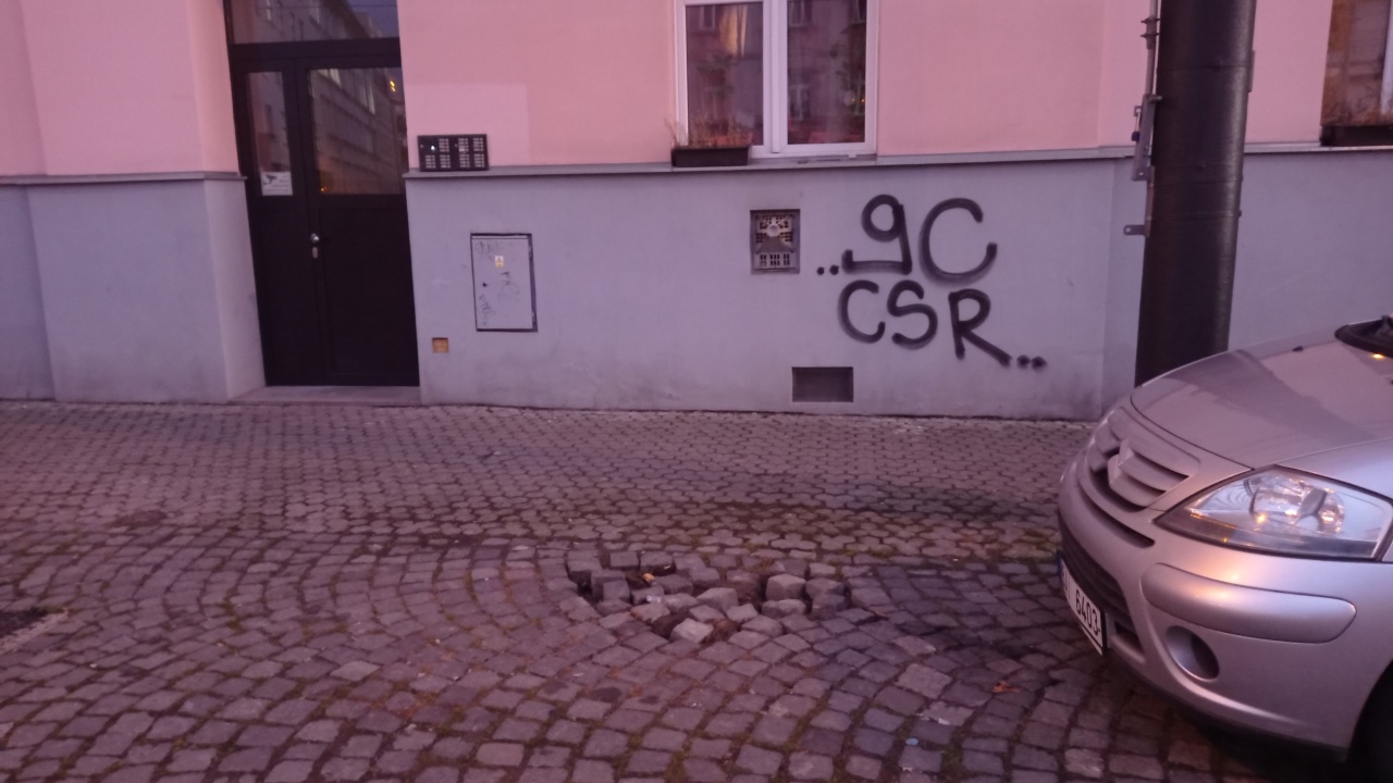 Rozbitá dlažba pěší zóny Na Žertvách u č.p. 880/38
