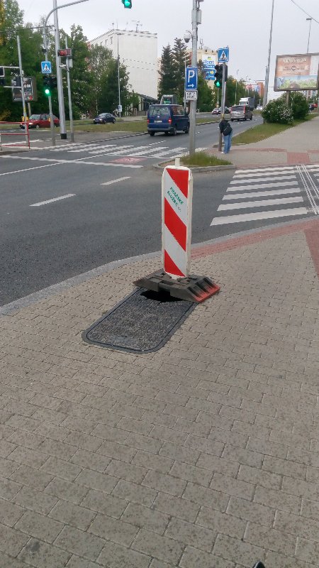 Díra v poklopu uprostřed chodníku u konečné busu 131