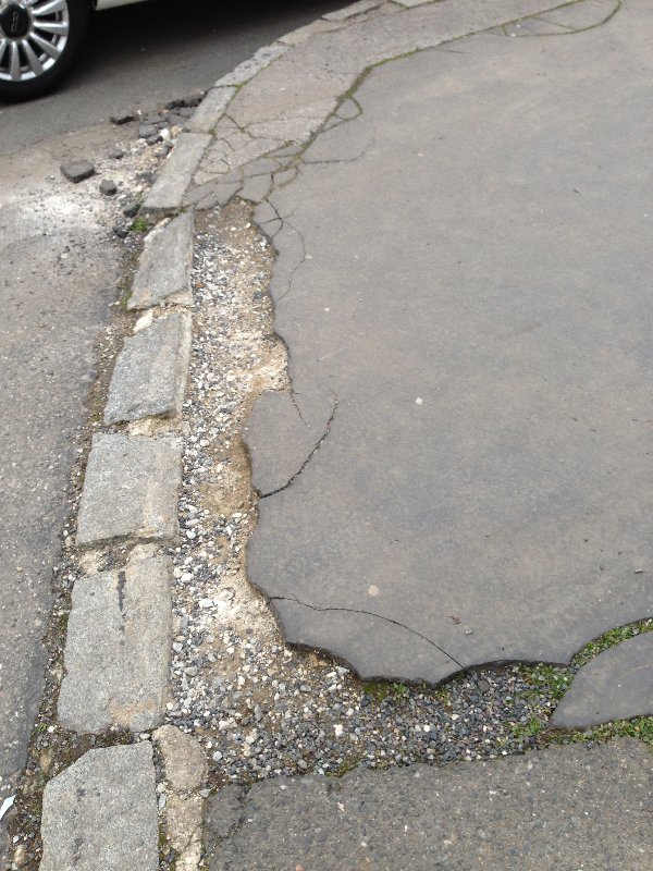 Drolící se asfalt na nároží Pod Altánem