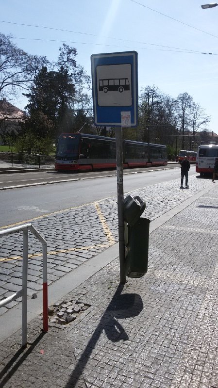 Ohnutá značka, rozbitý koš a rozbitá dlažba