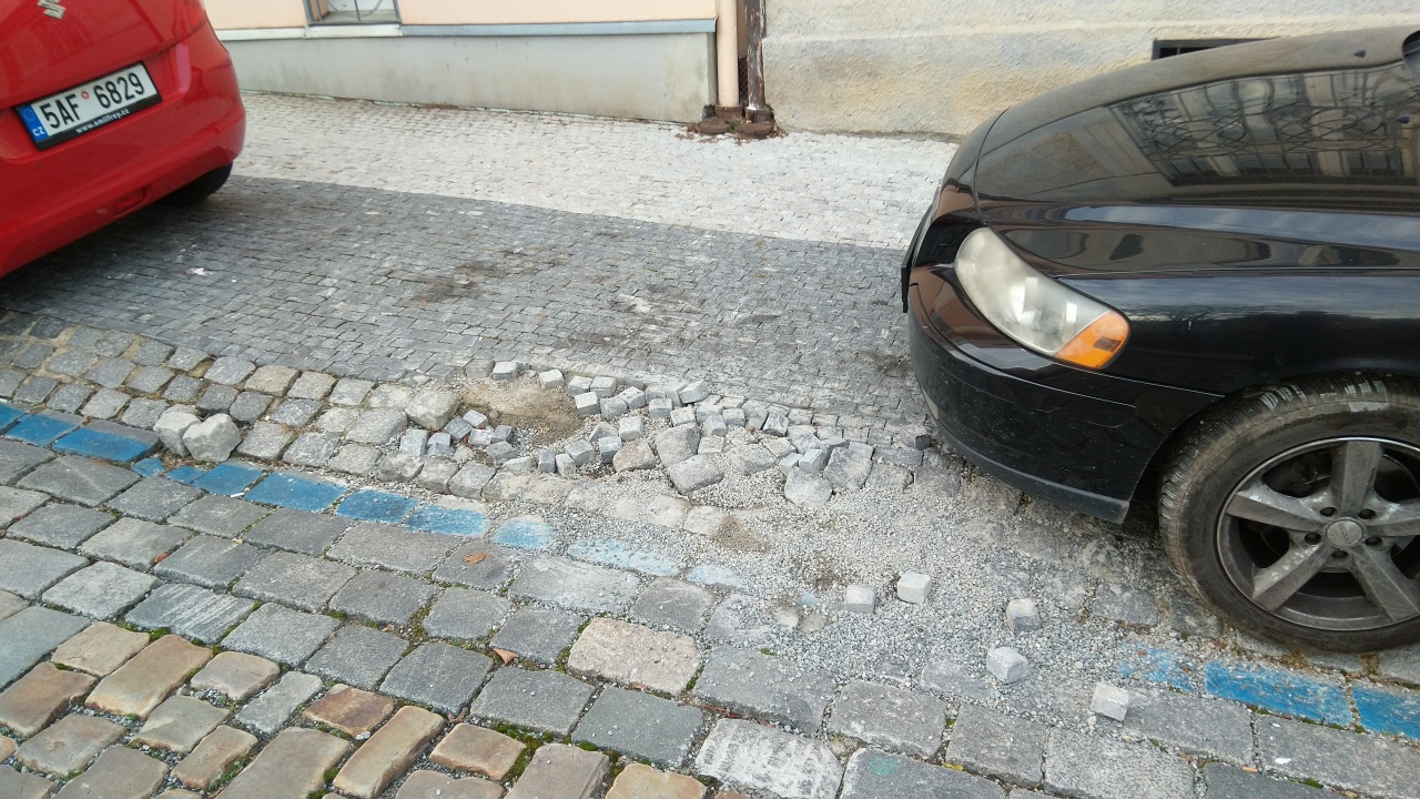 Rozpadající se dlažba chodníku v ulici Na Petynce