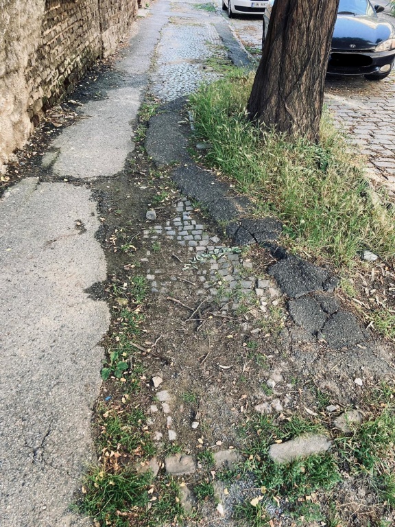 Rozbitý chodník v horní části ulice Na Petynce 