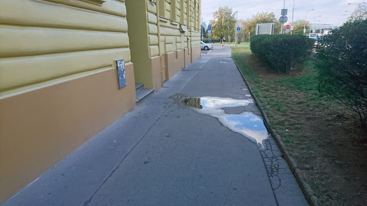 Špatně záplatovaný chodník před domem  Legerova 2