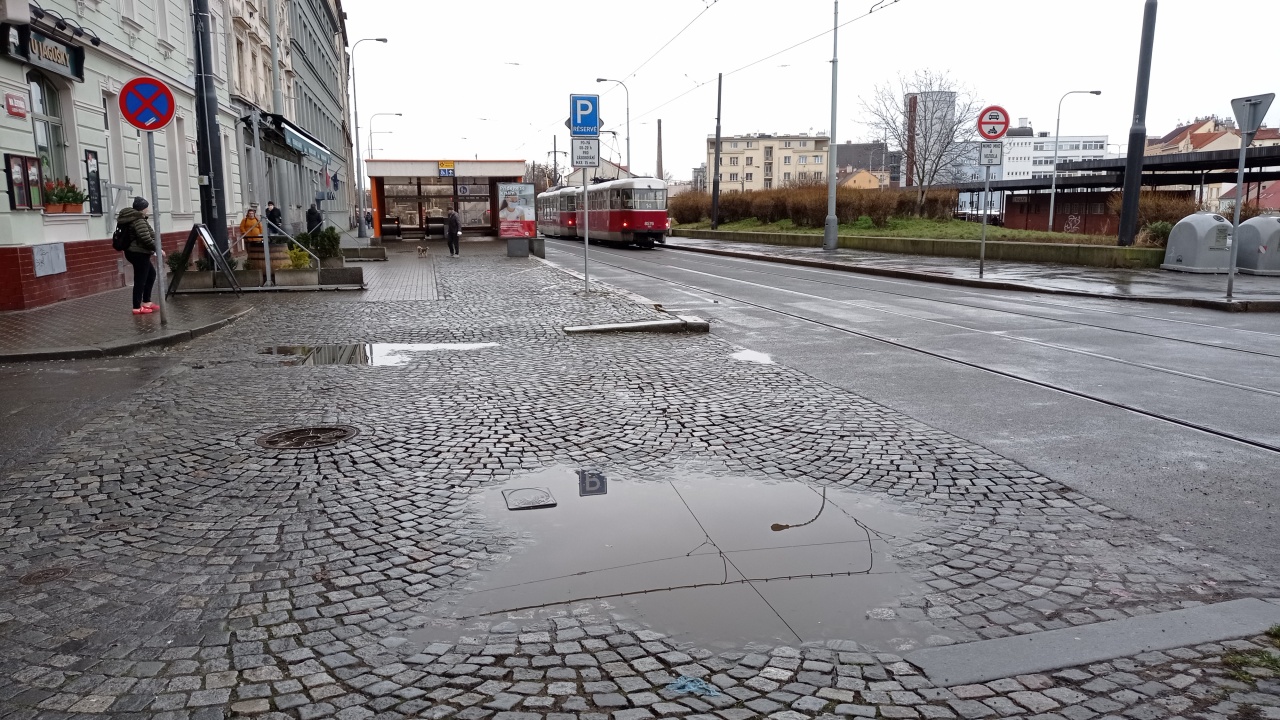 Propadlá dlažba s loužemi pěší zóny Na Žertvách