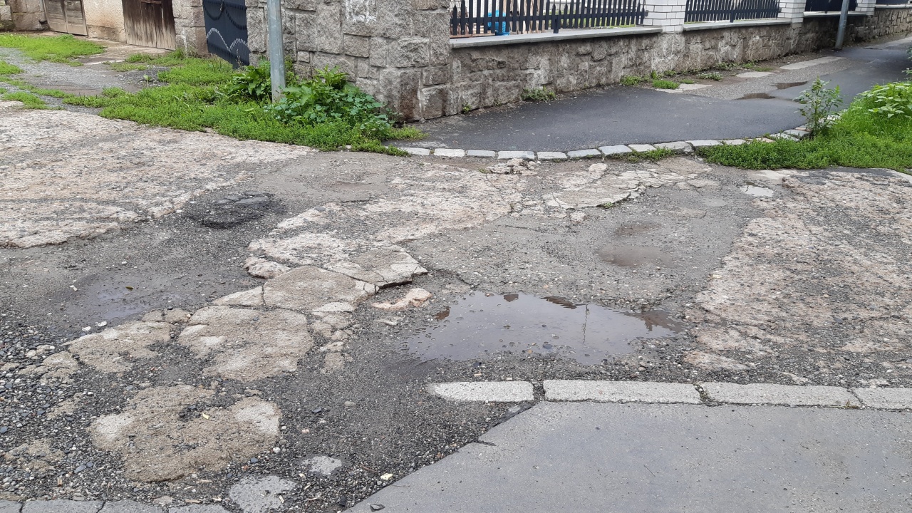 Rozbitý chodník na konci ulice Aldašínské, u trafostanice TS 2585