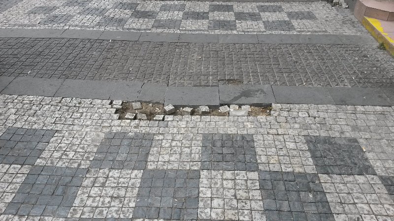 Rozbitý chodník vedle tramvajové zastávky náměstí Republiky