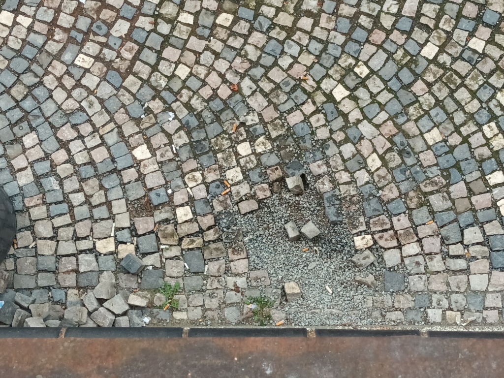Rozbitý chodník v ulici Nad Koulkou