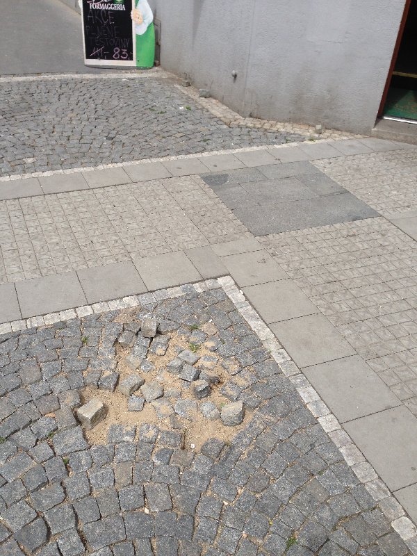 Rozbitý chodník na rohu Vinohradské a Baranovy