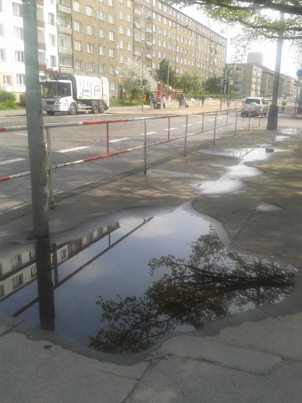 Louže v prohlubních na chodníku v Černokostelecké ulici