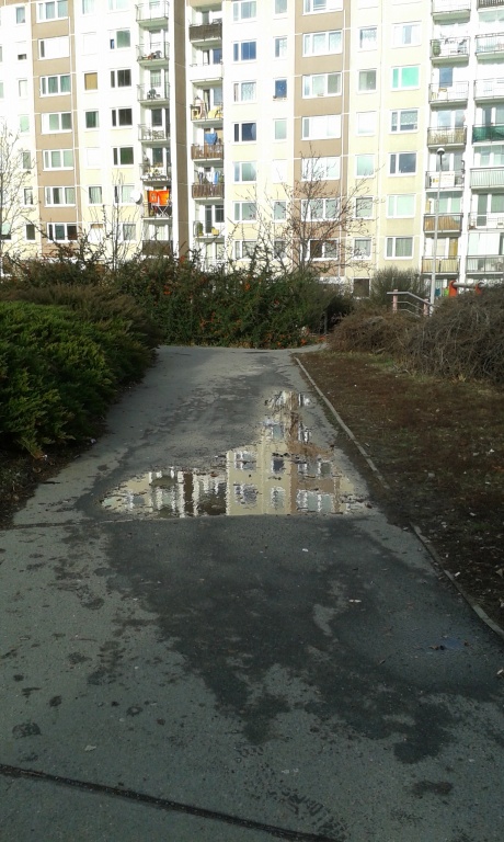 Téměř celoročně louže přes chodník, v zimě led (Barrandov)