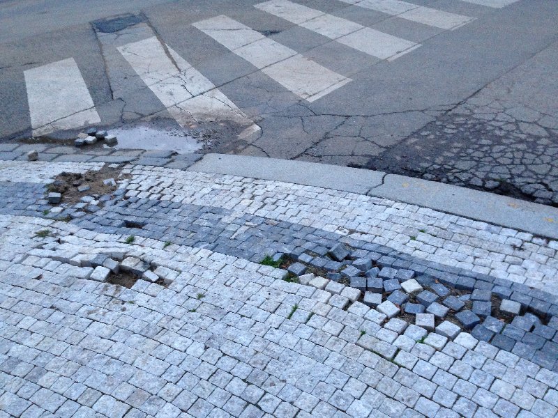 Rozpadající se chodník na nároží Šmilovského ulice