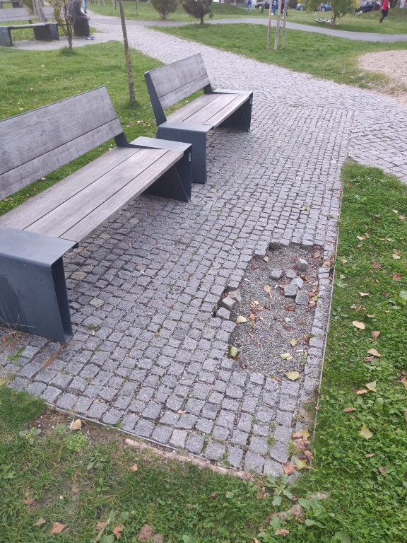 Chybějící dlažební kostky v parku Malinová - Chrpová