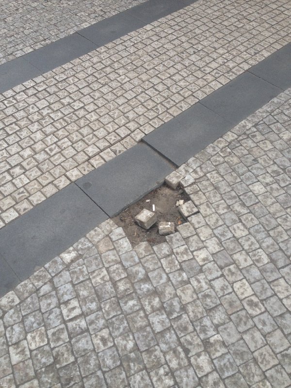 Rozpadající se dláždění na nám. Míru