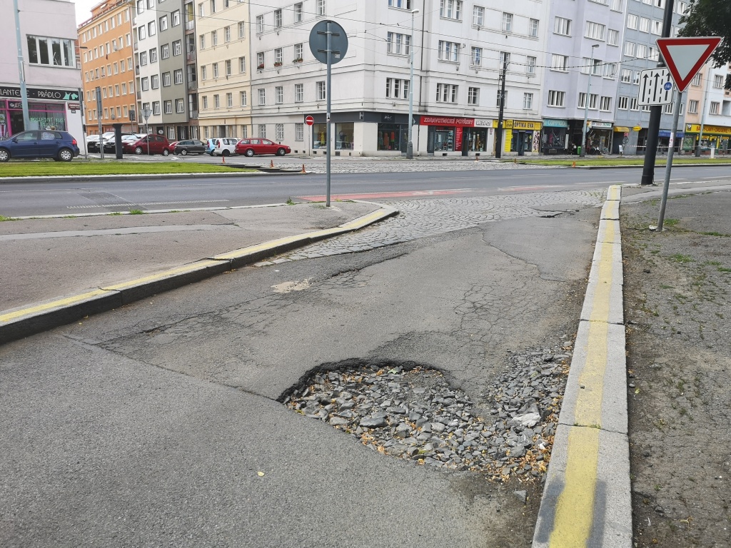 Výmol ve výjezdu z parkoviště u Olšanských hřbitovů (Vinohradská, P3)